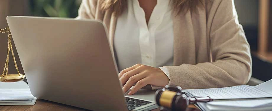 Como funciona o seguro garantia na execução fiscal? Na imagem, mulher com computador e martelo da justiça representa uma das partes envolvidas no seguro garantia da PGFN