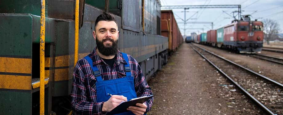 É obrigatório ter seguro de carga? Na imagem, transportador sorridente preenche formulário de análise de riscos do seguro de carga de transporte ferroviário