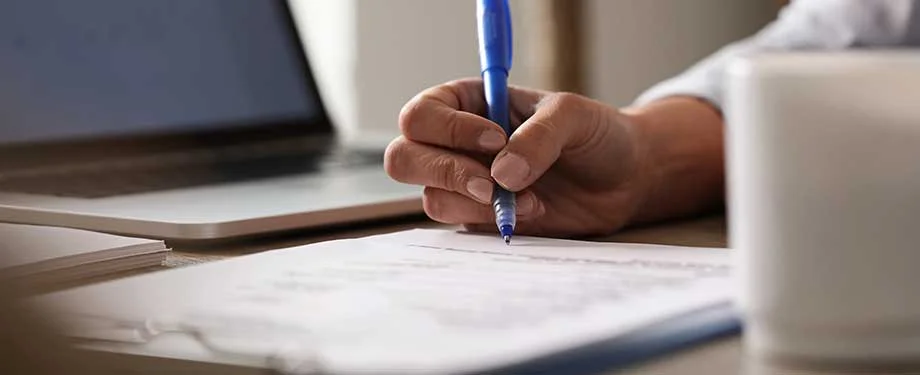 Como funciona o seguro garantia de obriga&ccedil;&otilde;es contratuais? Na imagem, pessoa assina contrato cuja obriga&ccedil;&otilde;es s&atilde;o asseguradas por meio do seguro garantia 