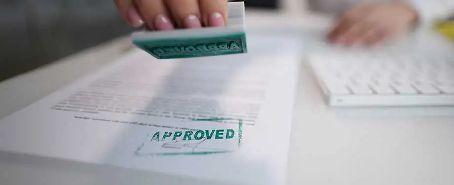 Como funciona o seguro garantia administrativo? Na imagem, carimbo de "aprovado" representa a possibilidade de usar o seguro garantia administrativo para assegurar o pagamento de dívidas fiscais
