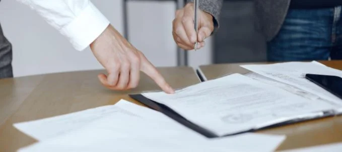 como-contratar-o-seguro-judicial Como contratar seguro judicial? Na imagem, sócios de uma empresa leem o que é o seguro judicial e como funciona.