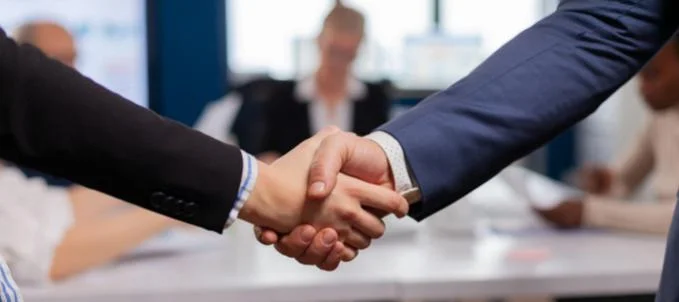 como-contratar-o-seguro-para-estagiario Como contratar seguro para estagiário? Na imagem, sócios se cumprimentando após entender como funciona seguro estagiário e decidir contratar as melhores coberturas.