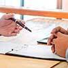 Pessoas assinando contrato representando o seguro garantia contratual do corretor online de seguros Mutuus